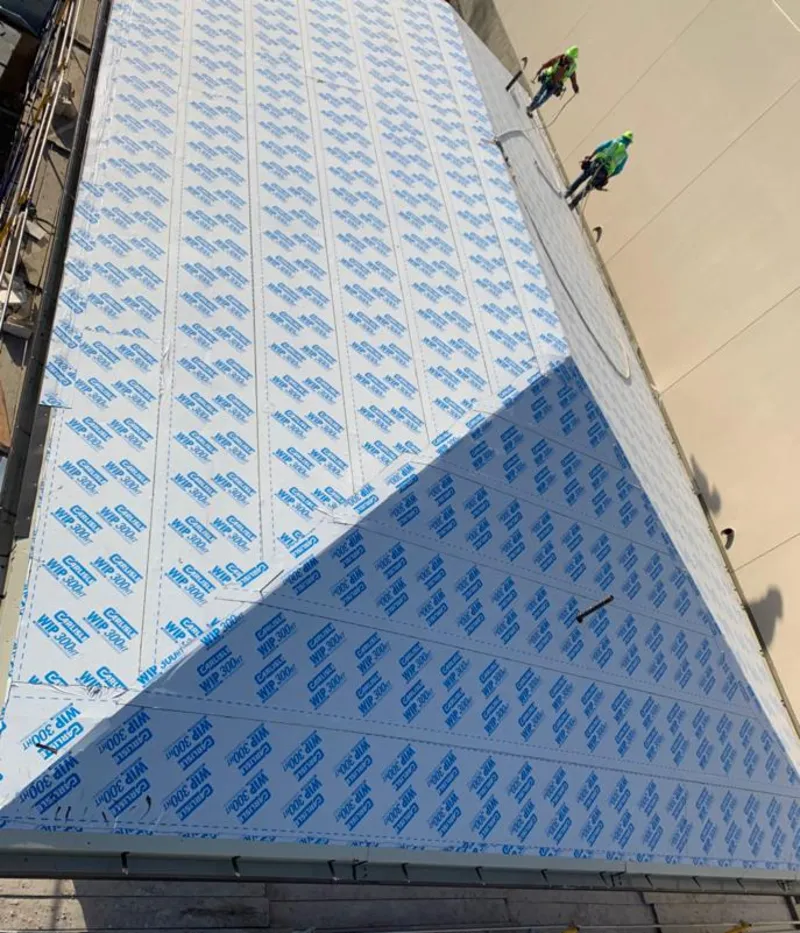 Professional roofers installing underlayment on a metal roof in Lansing